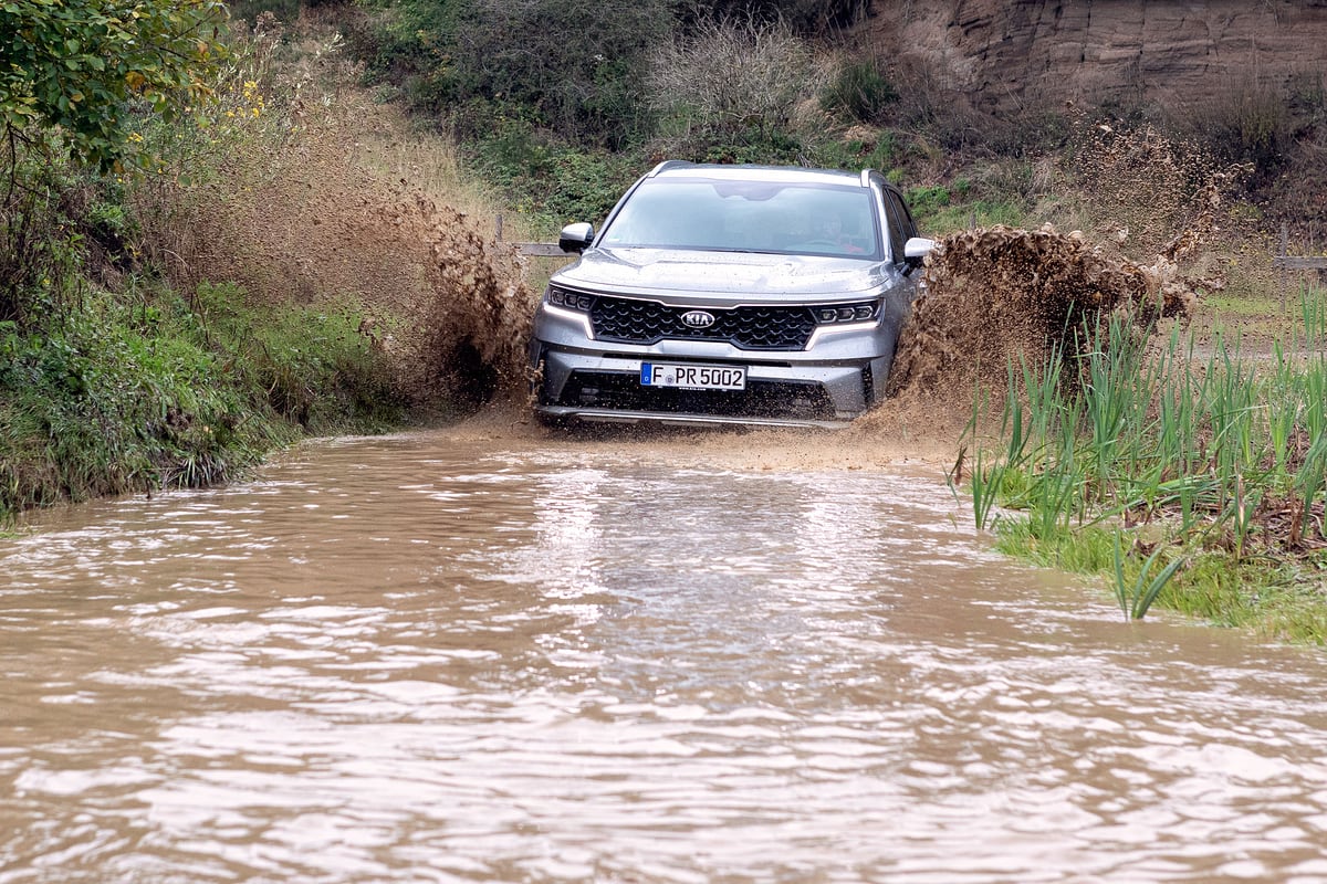 KIA Sorento bei einer Wasserdurchfahrt im Gelände, Wasser spritzt auf