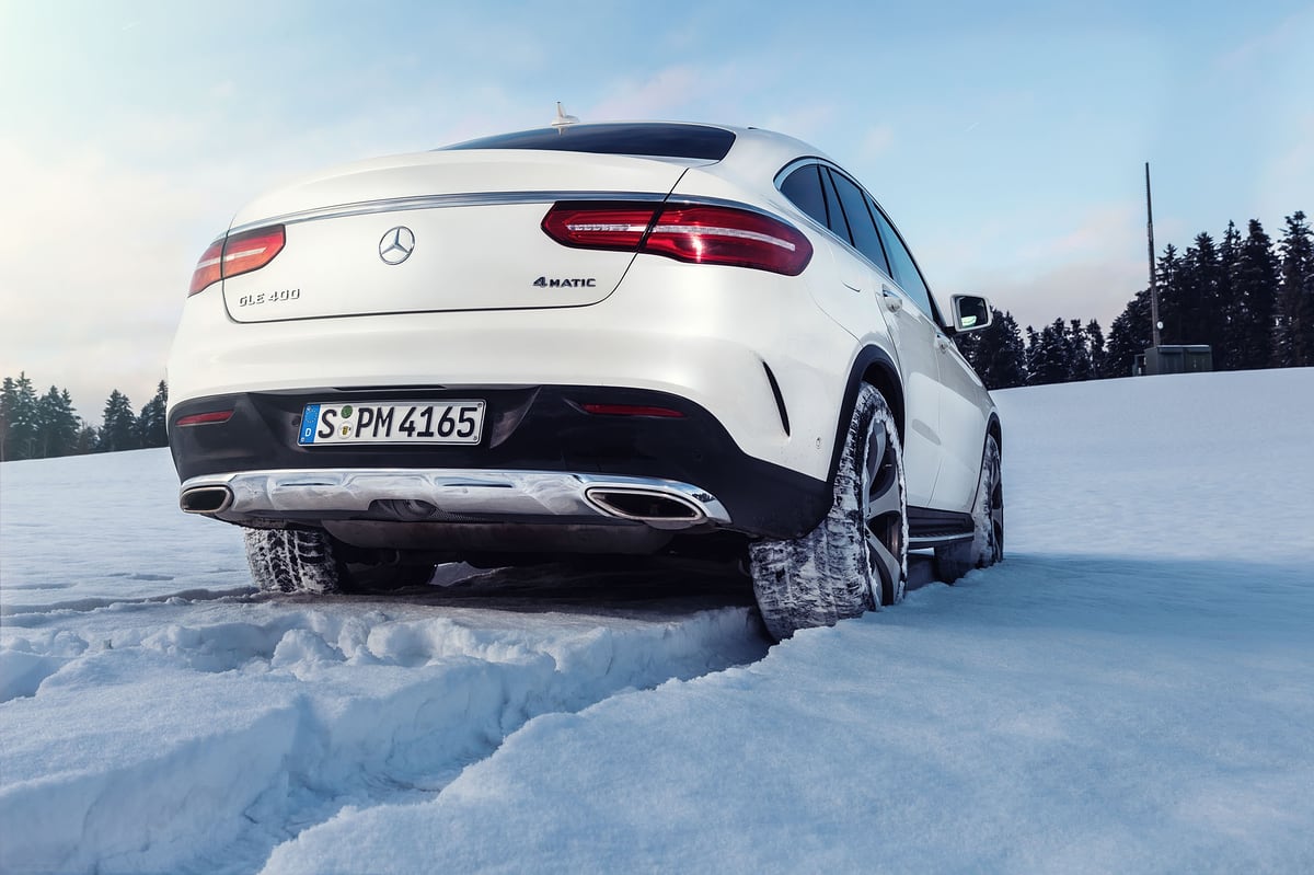 Heckansicht eines weißen Mercedes GLC Coupé im Tiefschnee