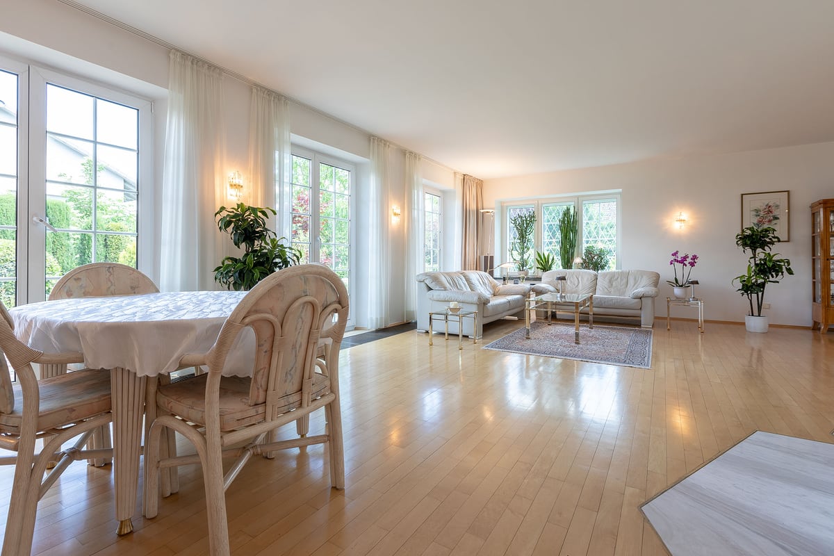 Helles Esszimmer mit Parkett und Blick in den Garten