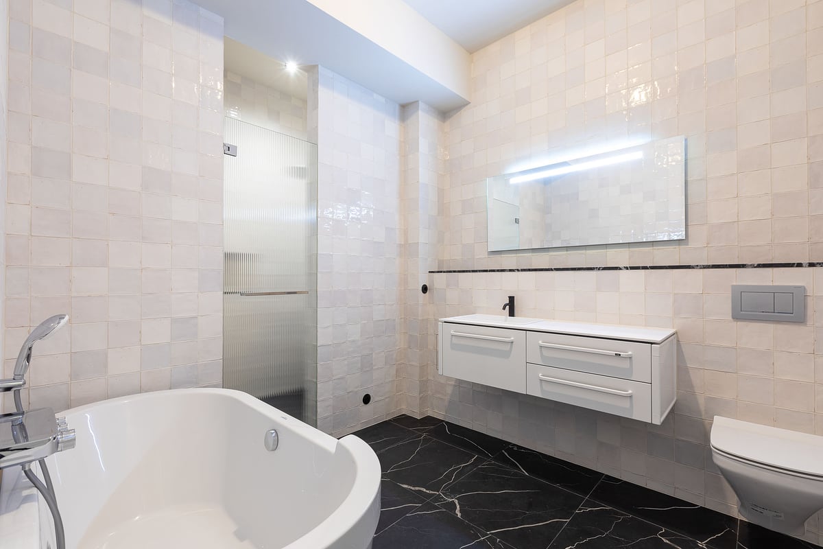 Helles Badezimmer mit freistehender Badewanne und Marmorfliesen