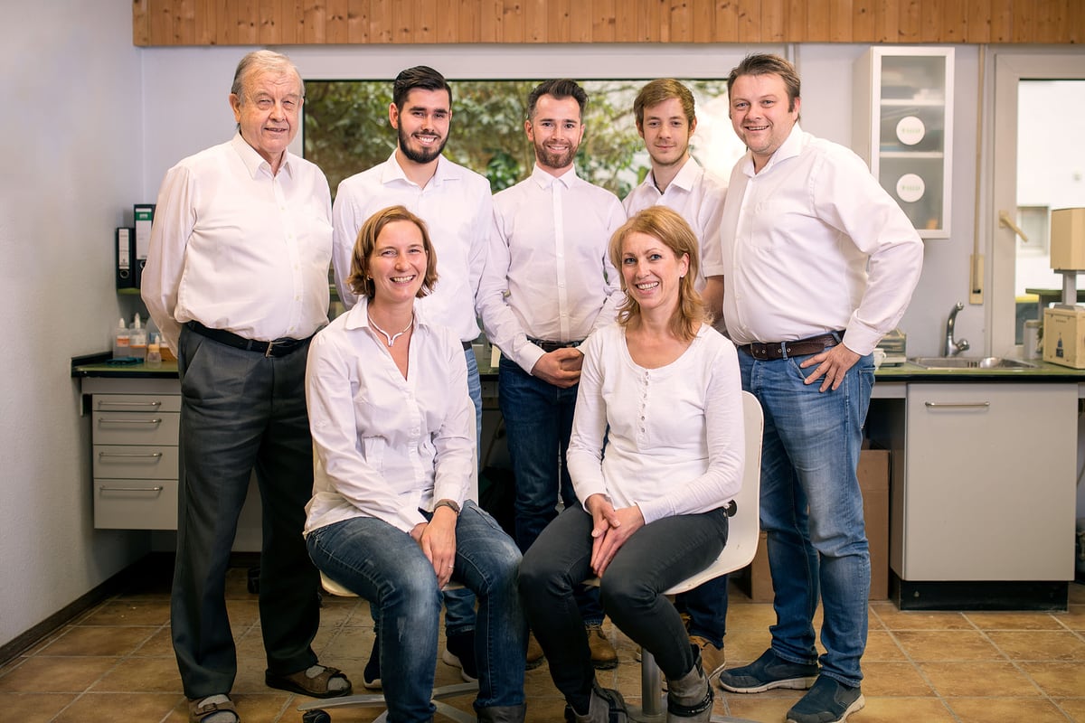 Team eines Dentallabors in weißen Hemden im Labor