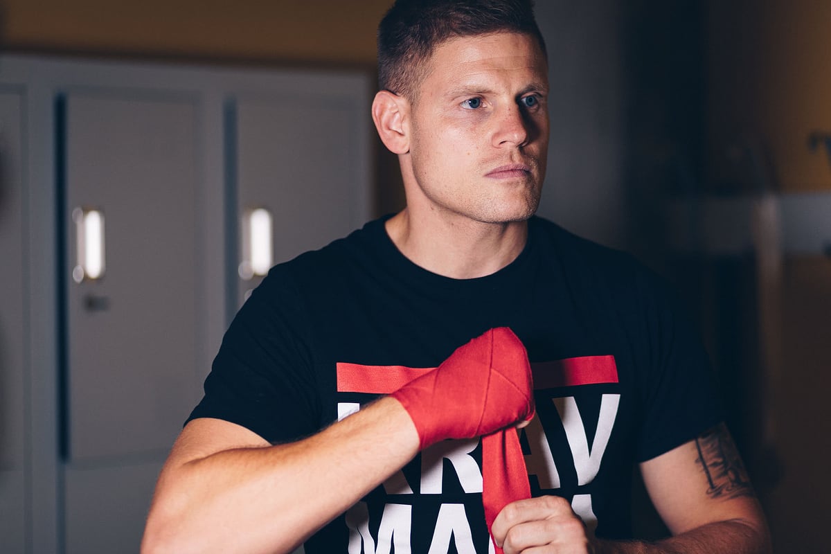 Portrait eines Kampfsporttrainers beim Bandagieren der Hände